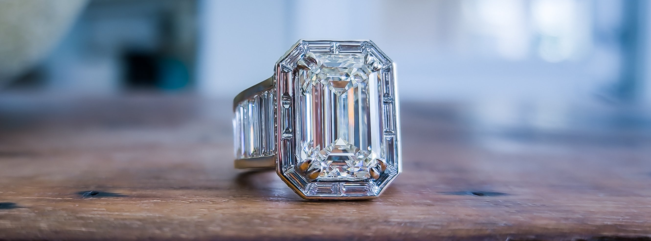Custom platinum ring with eight carat emerald cut diamond center, and custom baguettes